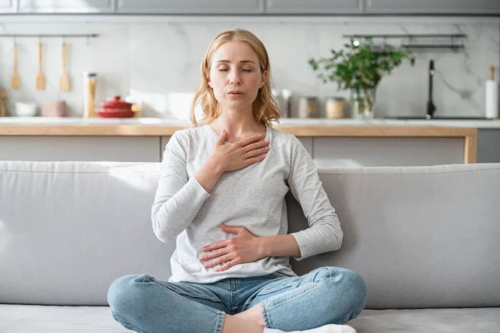 Osteopath for back pain Warrnambool tip: woman practicing diaphragmatic breathing to activate core, easing lower back pain.