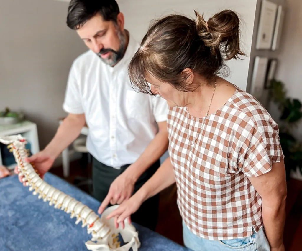 Osteopath and patient reviewing spinal alignment during chronic pain assessment in Warrnambool clinic