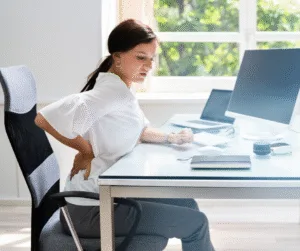 Woman sitting at desk with poor posture, a common cause of hip and lower back pain in Warrnambool
