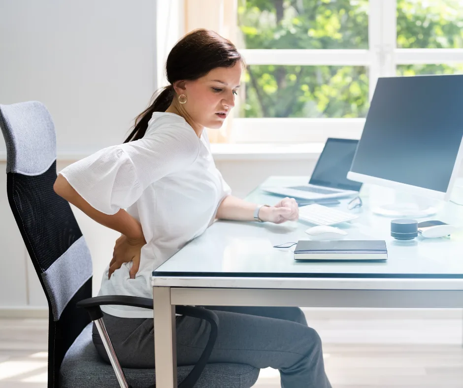 Woman sitting at desk with poor posture, a common cause of hip and lower back pain in Warrnambool