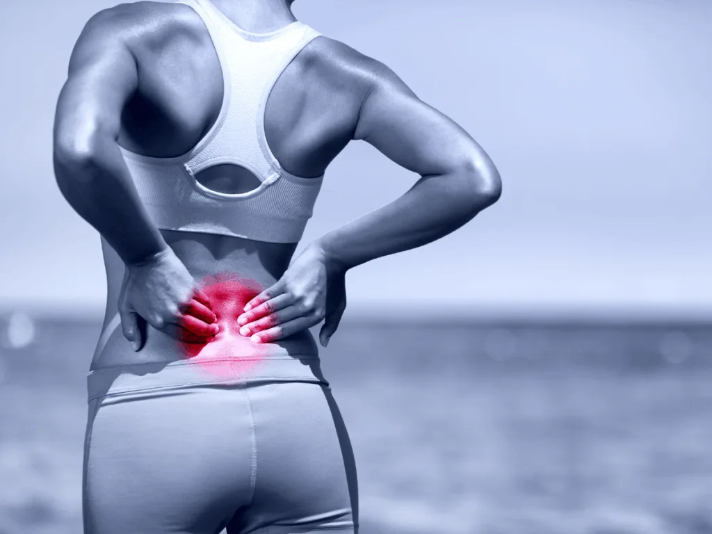 Athletic woman with highlighted lower back pain area, symbolising muscle fatigue and imbalance.